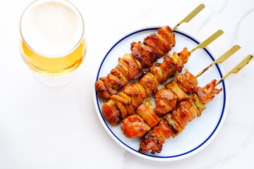 焼き鳥とビール - 焼き鳥（タレ）の盛り合わせと、ビールのグラス
