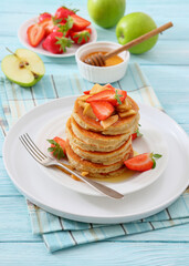 pancakes topped with apple slices and strawberries