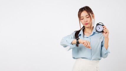 Woman checks watch time while holding an alarm clock, a reminder of being late or an appointment,...