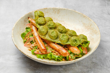 Delicious green waffle with grilled sausage and fresh vegetables served in a stylish bowl
