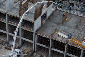 Construction Spider Crane Working on a High-Rise Building Using Machinery and Scaffolding in an Urban Environment