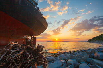 Stranded ship after a storm at sunset
