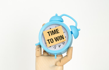 A blue alarm clock with a white face and a black and white sign that says Time to Win