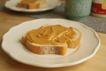 Plate with toast and peanut butter and honey on a kitchen counter,
