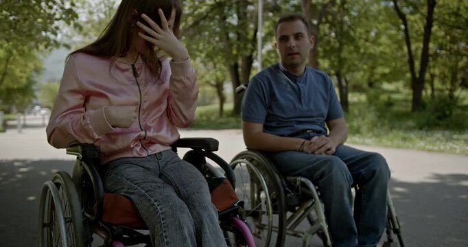 Two friends in wheelchairs share a meaningful conversation in the park. This scene highlights connection, support, and inclusion for people with disabilities, promoting positive social interaction.