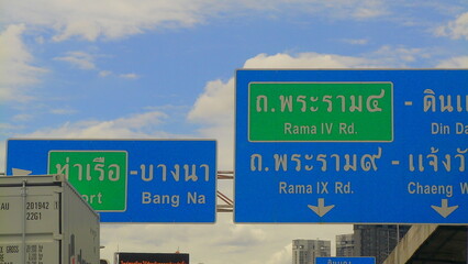Roadside highway sign in Bangkok indicating junctions for Bang Na and Rama IV Rd, captured under a...