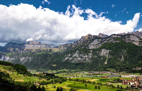Switzerland, Swiss Alps, Canton St. Gallen, Fr&uuml;msel and Hinterrugg mountains, town of Flums in the valley, summer 2025. Sunny day with clouds, beautiful mountain range. 