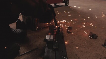 Close-up of welder working with metal, producing sparks during welding process in industrial workshop. Concept of metal fabrication, factory manufacturing, industrial labor, safety equipment, welding  - Powered by Adobe