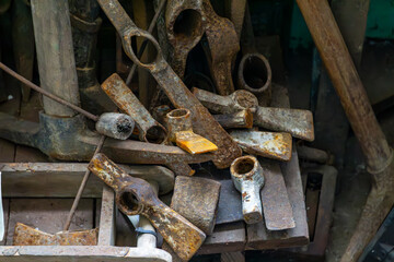 Rusty industrial tools on a wooden workbench in an old workshop. Patina and corrosion highlight...