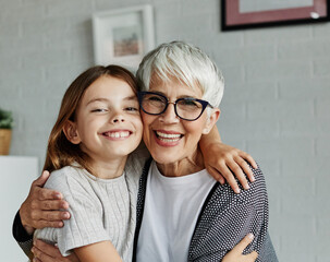 Portrait of Grandmother and granddaughter or daughter having fun hugging and bonding together at...