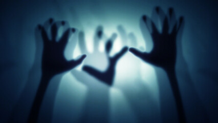 Silhouettes of many human hands behind translucent glass, curtain. The concept of the other world, victims of violence, paranormal phenomena, ghosts, zombies.