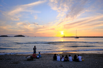 Kusadasi, Turkey; April 19 2025: A group of people enjoying the sunset at the beach, Kusadasi,...