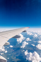 Obraz premium View from the airplane window at a beautiful cloudy sky and the airplane wing