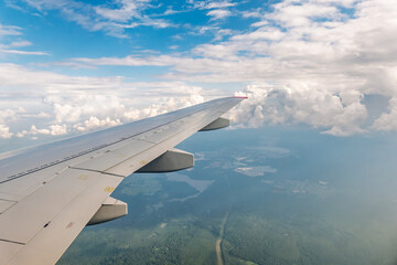 Obraz premium View from the airplane window at a beautiful cloudy sky and the airplane wing