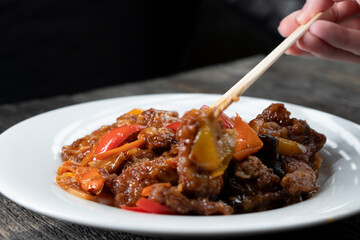 Stir Fried Eel with Vegetables on wooden background. Chinese food. Asian cuisine