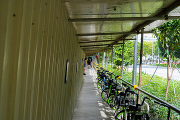 covered walkway with parked bicycles and greenery in an urban setting