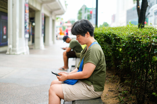 casual sidewalk scene with people relaxing and using mobile devices
