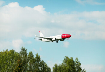 A white and red flying plane against a blue sky background on a clear sunny day. Transport planes rockets helicopters.
