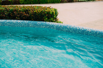 A serene turquoise pool surrounded by lush greenery offers a perfect atmosphere for relaxation...