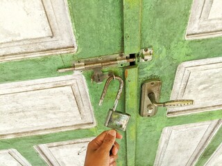 A man's hand unlocking a door