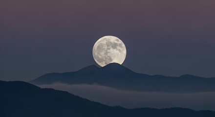 Full Moon Rising Over Dark Mountain Ridge at Dusk in Dramatic Sky