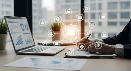 A businessperson analyzes data on a laptop and takes notes on a clipboard with digital icons.