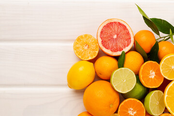 Different citrus fruits on wooden background, top view