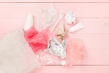 Bag with unsorted waste on wooden background, top view