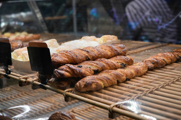 Display of chocolate croissants and other pastries in a bakery or cafe, Focus: food, pastry, and bakery setting