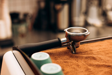 Close-up of portafilter on espresso machine in cozy coffee shop.