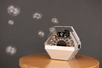 Close-up of bubble machine creating soap bubbles on outdoor table.