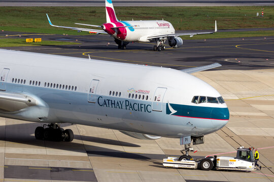 Cathay Pacific Boeing 777 towed on the tarmac after arrival at Dusseldorf Airport, showcasing ground handling operations and aircraft logistics (2015).