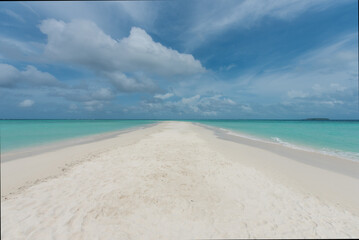White sand stretches to the sparkling sea on a bright,