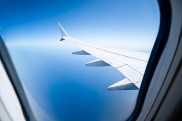 Airplane wing seen from a window. The plane flies over the holiday island of Cyprus.