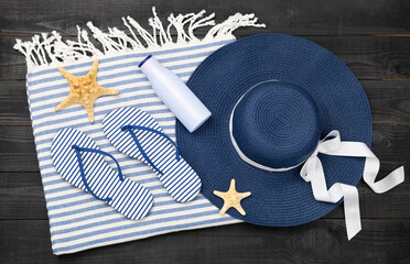 Blue beach accessories on wooden background, top view. Flat lay