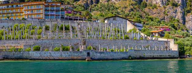 Scenic waterfront of Limone sul Garda, with village buildings and mountains in the background.
