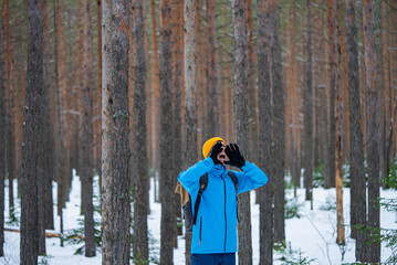 Hiker wearing blue jacket and yellow hat shouting desperately, wandering through snow-covered...