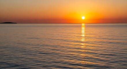 Fototapeta premium A serene sunset over the ocean, with a golden sun reflecting on the water and a small island visible on the horizon.