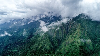 Obraz premium Panoramic views of mountains with dense forests and clouds rolling over peaks, showcasing rugged beauty, natural landscapes with lush greenery and misty summits under open skies.