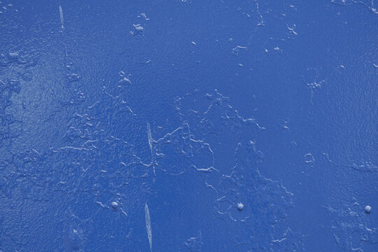 A vibrant blue surface displays intricate variations in texture with subtle ridges and marks. The light plays on the surface, highlighting the unevenness and providing a dynamic visual experience.