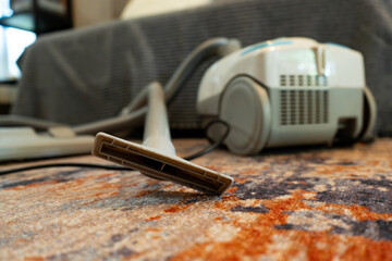 vacuum cleaner equipment on a patterned rug in a modern minimalist house, with warm lighting environment 