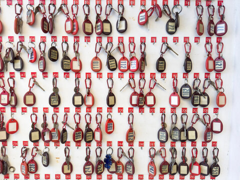 Hanging keys with numbers on a white background in a vintage hotel reception area