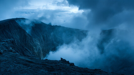 Fototapeta premium Crater Edge with Volcanic Soil and Faint Steam Rising Under Blue Twilight - beautiful image, nature view, real look
