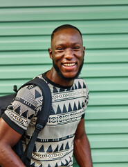 Portrait of a smiling young man guy posing by a green wall and walking in the city, tourists...