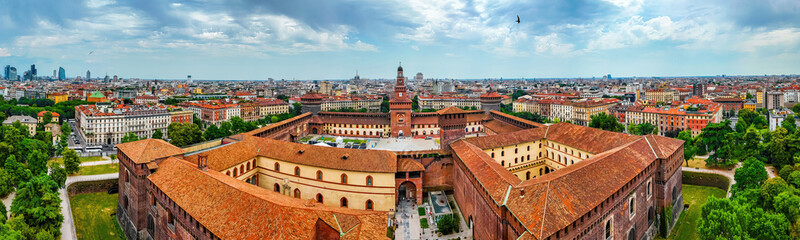 Historic Sforza Castle tower in Milan with medieval brickwork, large clock, and decorative details...