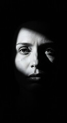Monochrome Portrait of Woman with Intense Gaze in Dark Setting