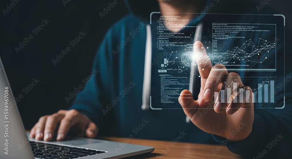 Poster person in hoodie interacts with holographic data display projected above a laptop, possibly related 