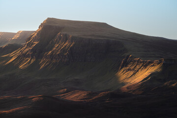 Close-up view of the Trotternish Ridge with crisp morning sunlight and clear blue sky. Isle of Skye, Scotland, UK.