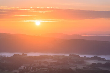 Golden sunrise with beautiful view of misty hills in the British countryside.