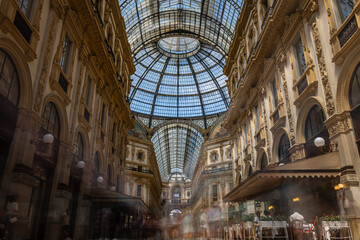 Obraz premium Interior view of Galleria Vittorio Emanuele II in Milan with glass dome, ornate facades, and decorative fresco under bright daylight